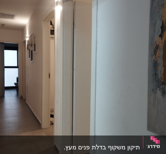 מסדרון עם דלתות פתוחות ותאורה על הקיר